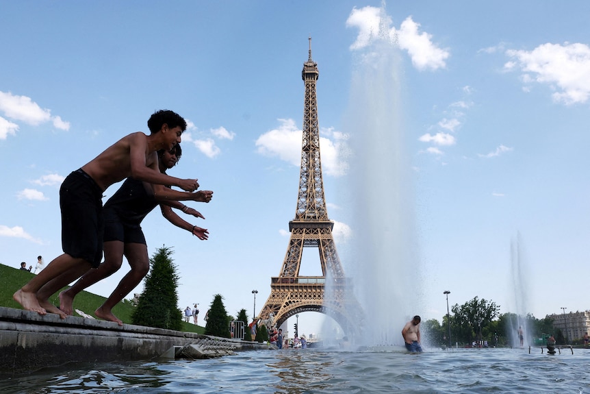People cool off in the Trocadero Fountain next to the Eiffel Tower.