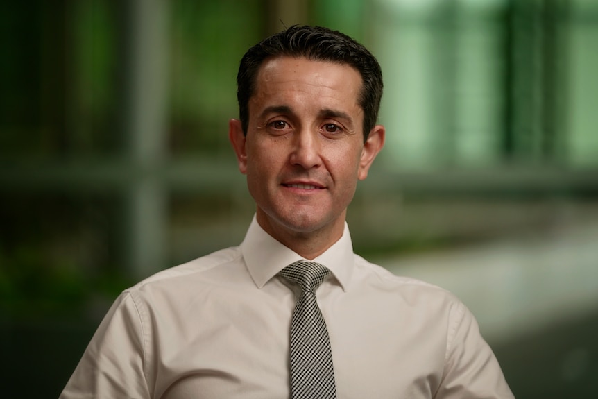 A profile image of a man with short, dark hair, wearing a pale shirt and brown tie.