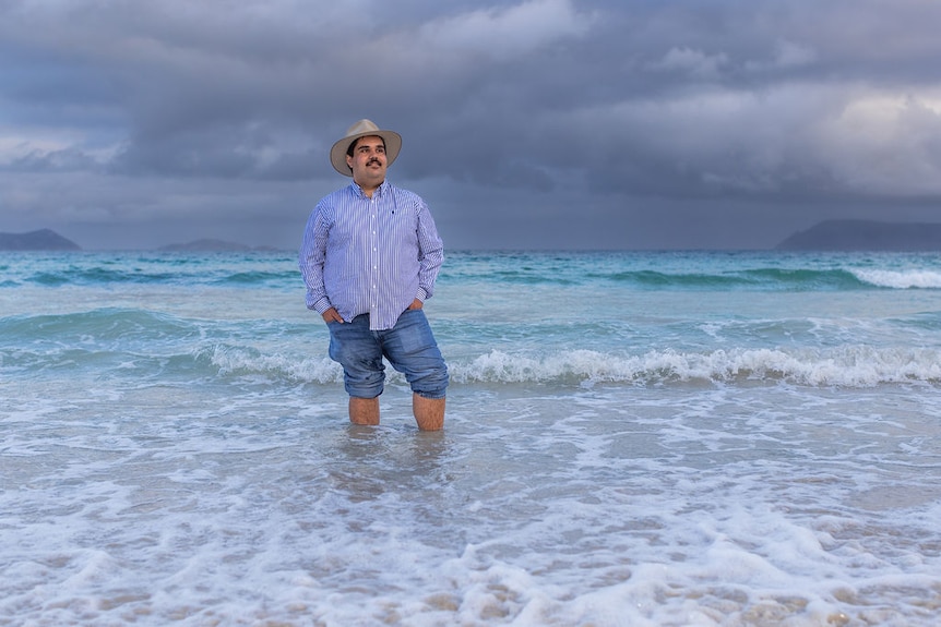 A man standing in the ocean.