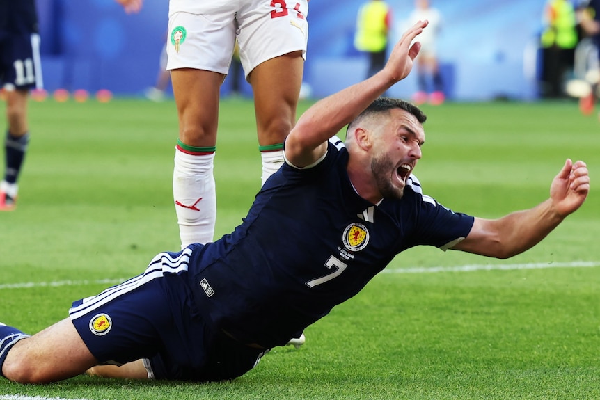 John McGinn dives to the ground while playing for Scotland