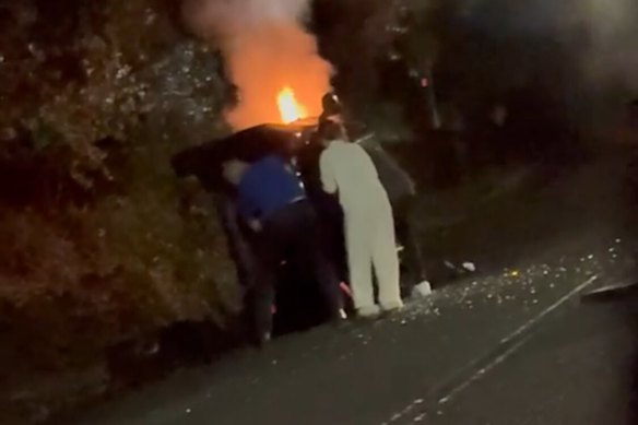 Parramatta coach Jason Ryles, still wearing his Eels polo shirt, pulls the woman from a burning car.