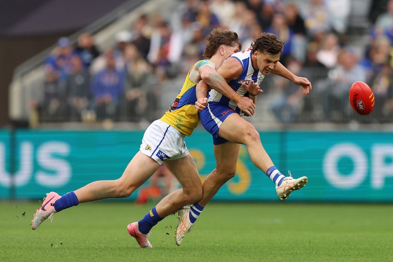 Cooper Harvey of the Kangaroos kicks the ball.