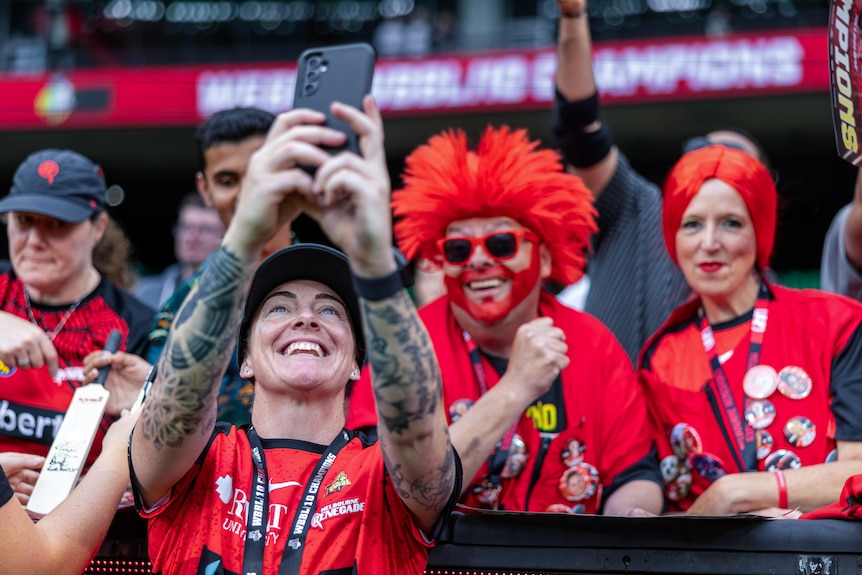 Sarah Coyte takes a photo with Melbourne Renegades fans after the 2024 WBBL grand final.
