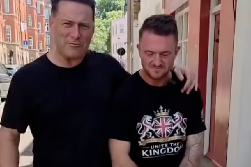 Karl Stefanovic and Tommy Robinson walk along a street. Stefanovic's arm is around Robinson.
