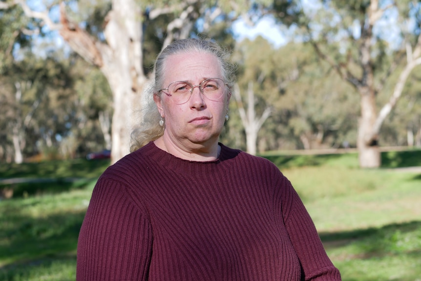 Woman in a maroon dress sitting in a park