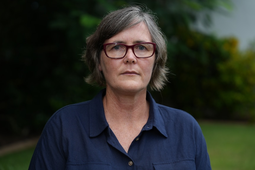 A woman staring seriously down lens.
