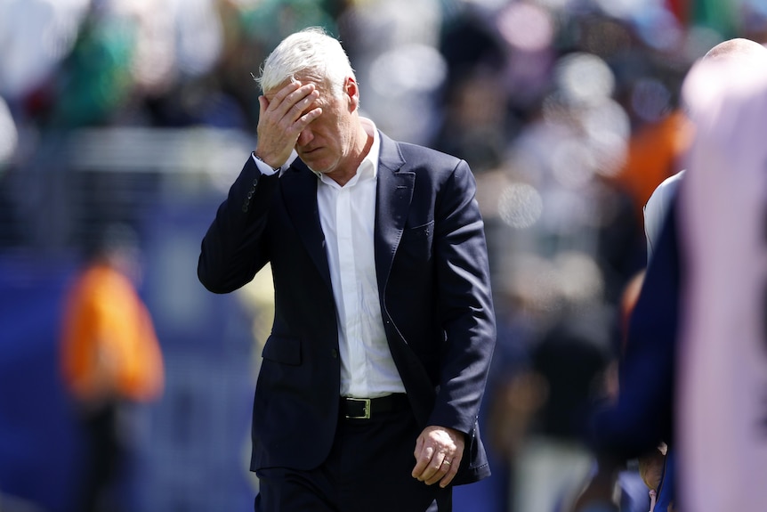 Didier Deschamps holds his hand to his head.
