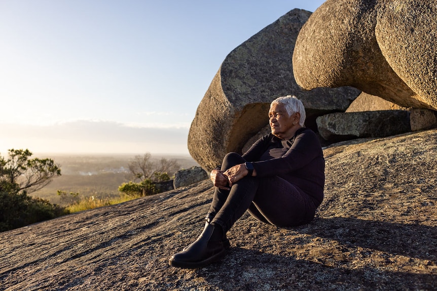 A woman sitting on a rock