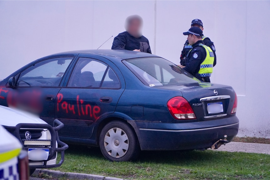 A blurred image of a car with red paint reading "F*** pauline". Near a protest against Pauline Hanson in Midland.