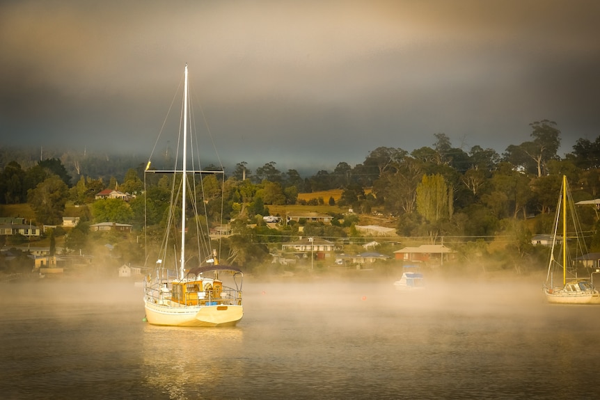 A boat on a river clouded in mist.