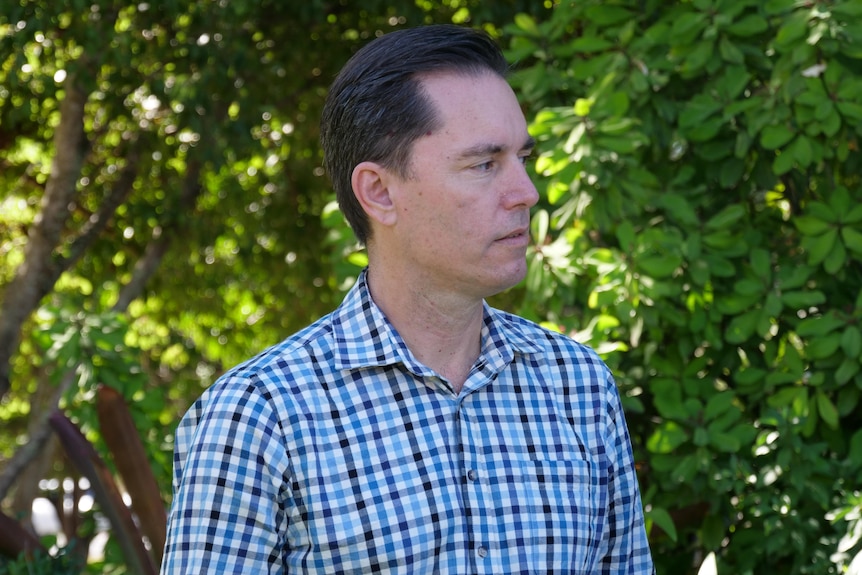A man is staring intenly at an individual out of frame as they speak.