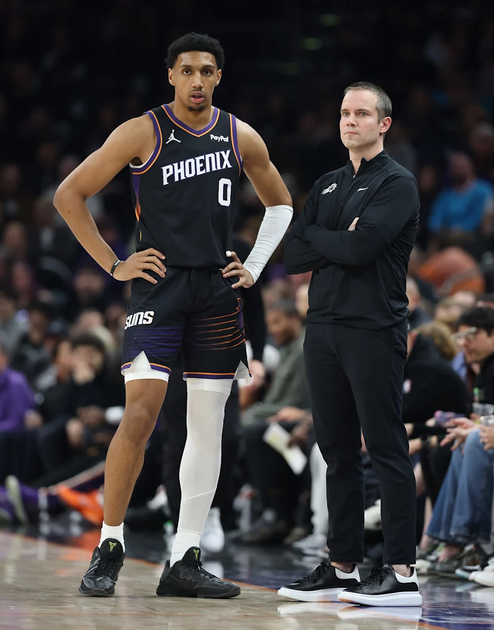 Ryan Dunn #0 of the Phoenix Suns stands with head coach Jordan Ott during the first half of the NBA game against the Washington Wizards at Mortgage Matchup Center on January 11, 2026, in Phoenix.