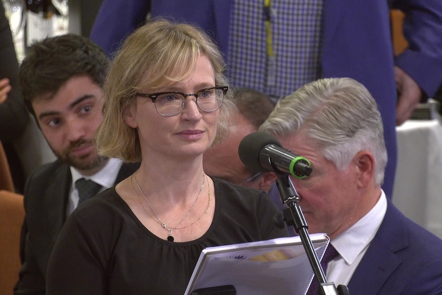 A woman talks into a microphone