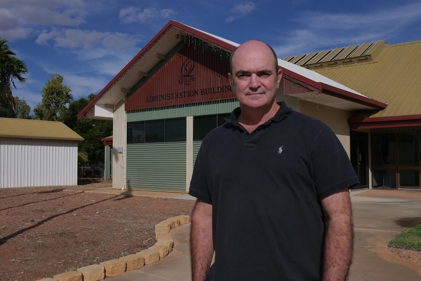 Middle aged man stands out front of council building