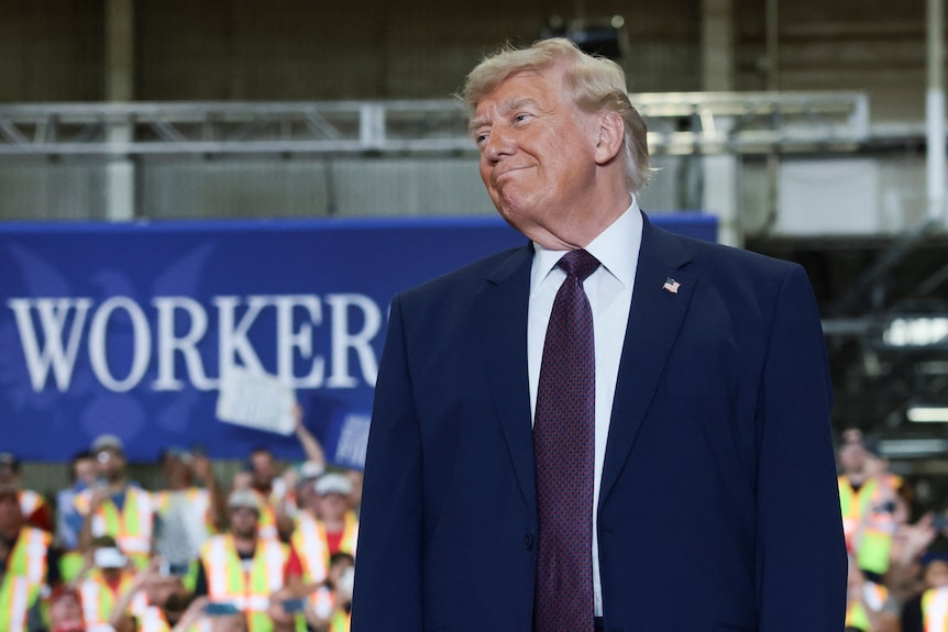 Donald Trump smiles while looking to the side.