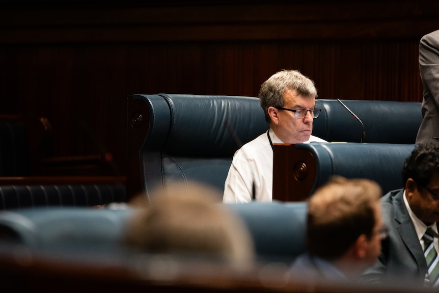 Dave Kelly sitting and working in Parliament.