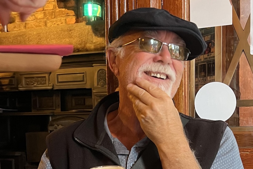Paul Beard holds a drink in one hand.