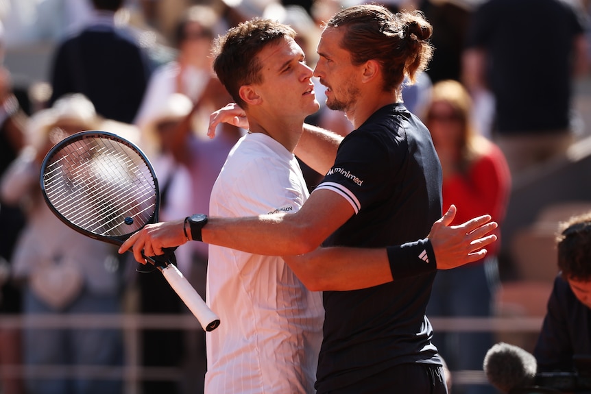 Jakub Menšík and Alexander Zverev hug on court.