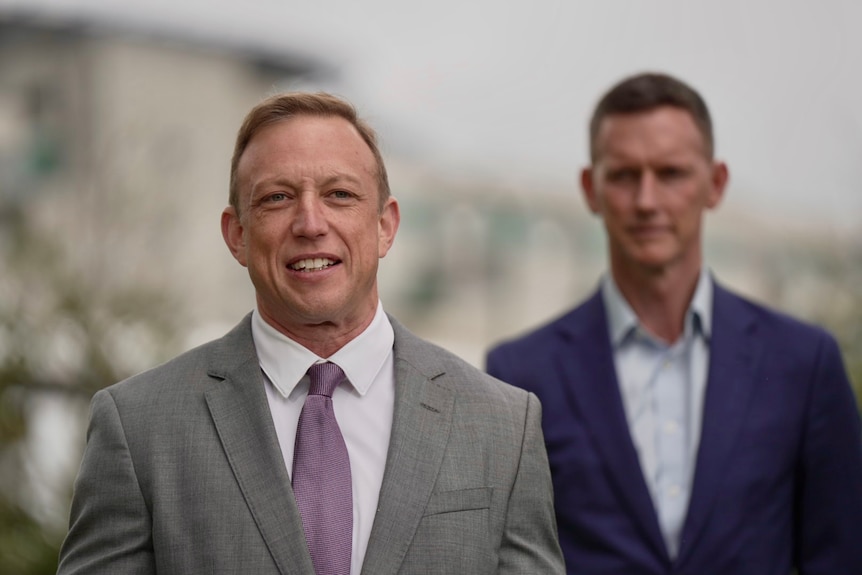 A photo showing Steven Miles standing with another man behind him.