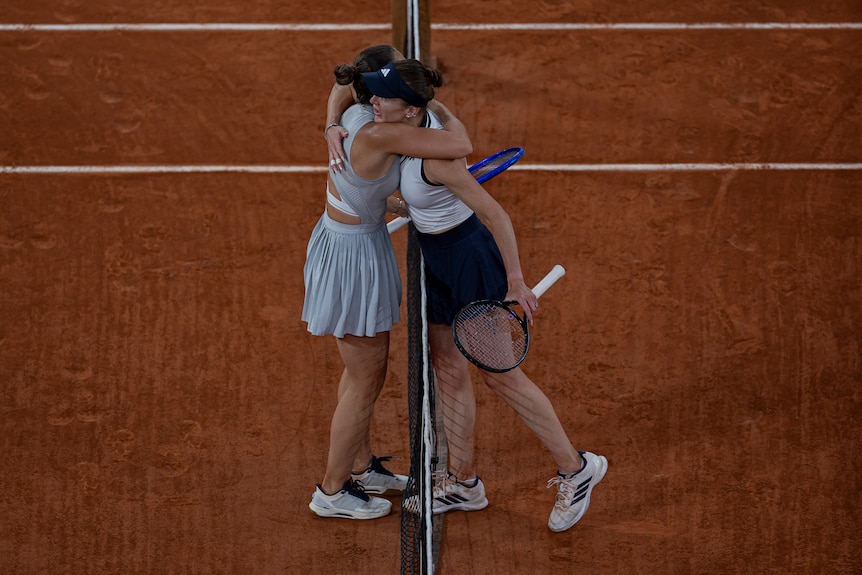 Marta Kostyuk and Elina Svitolina hug over the net at the French Open.
