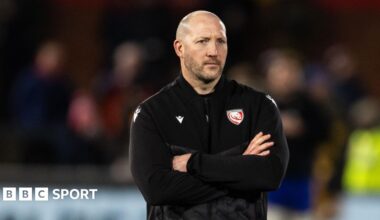 Gloucester director of rugby George Skivington stands wearing a black team polo jumper with his arms folded across his chest