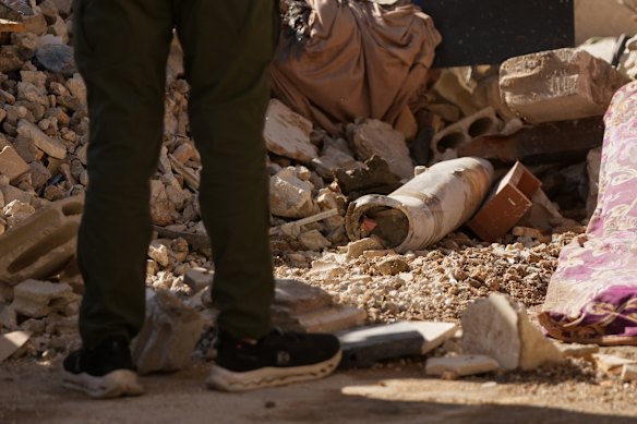 A man stands next to an unexploded missile at the site following an Israeli airstrike in Dahiyeh.