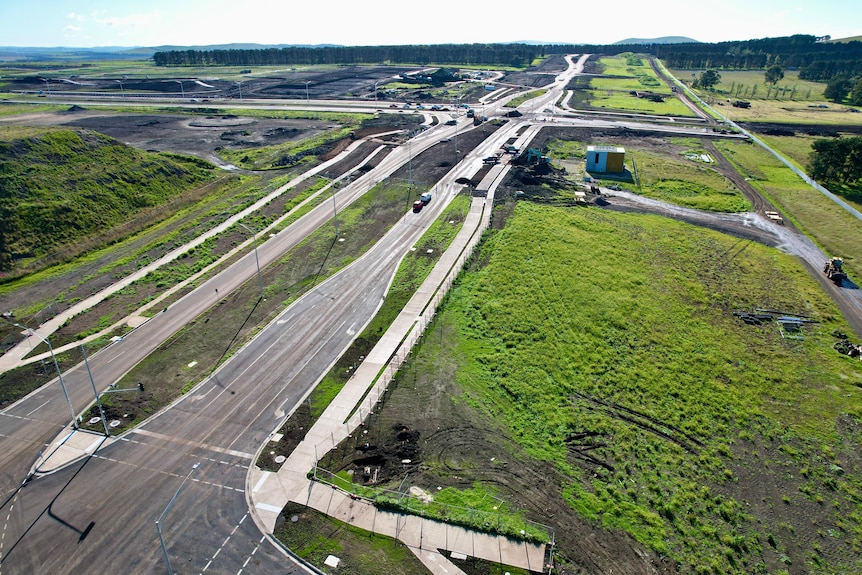 Suburban development with new dual lane road cutting across green pastures