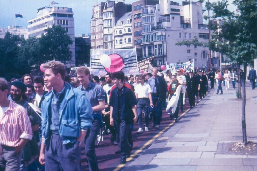 Grainy photo of a parade of mostly young men with banners through a London street