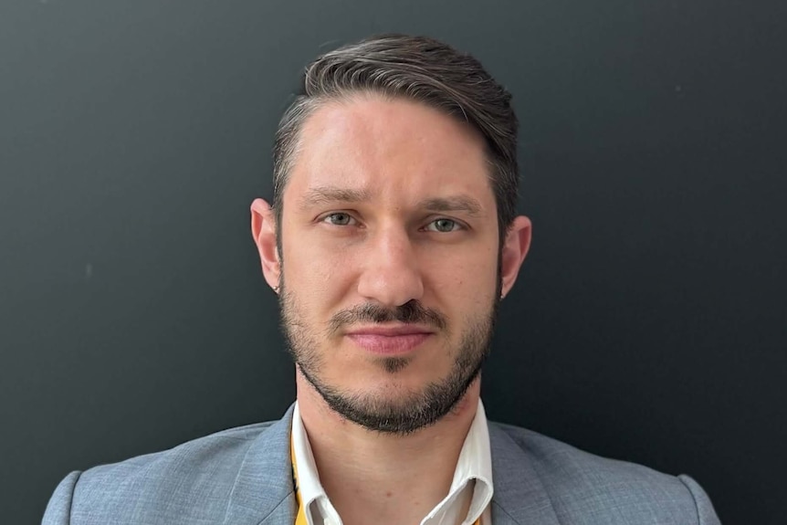 A man with short dark hair and a short facial hair. 