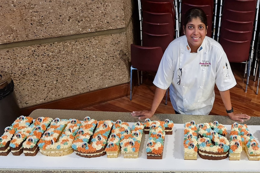 Cake decorator Ishani Harney stands beside a cake she created for Mount Isa's 100th anniversary celebrations.
