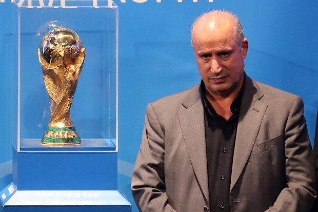 President of the Iranian Football Federation, Mehdi Taj poses for a photo with the FIFA World Cup Trophy
