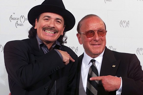 Carlos Santana, left, and co-producer Clive Davis pose with their award for favourite pop/rock album at the American Music Awards in 2000.