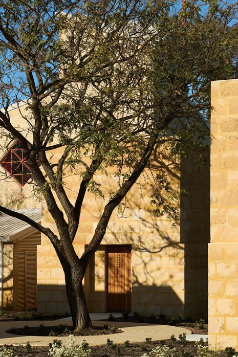 The soft golden colour of the local limestone blocks recalls the brickwork of the existing parish church.