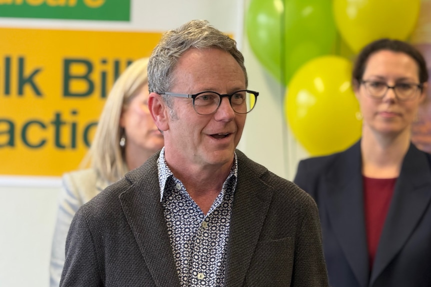 Chief Medical officer of OCHRE speaking at Woden Bulk Billing clinic at Woden wearing glasses and a dark cardigan