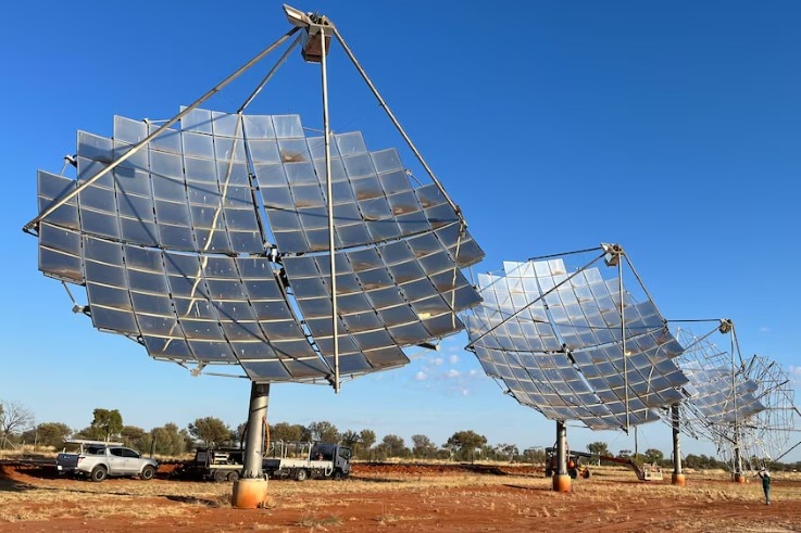Large metal dishes mounted above red dirt.