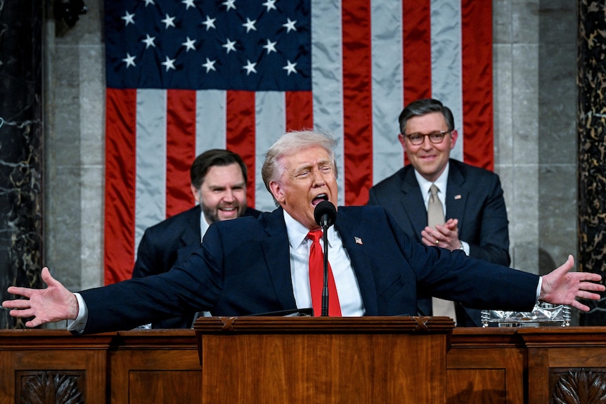 donald trump extends his arms as he shouts during a state of the union speech