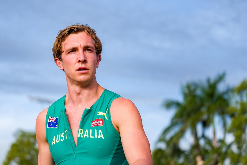 Josh Azzopardi stands in front of palm trees at the Oceania Athletics Championships.
