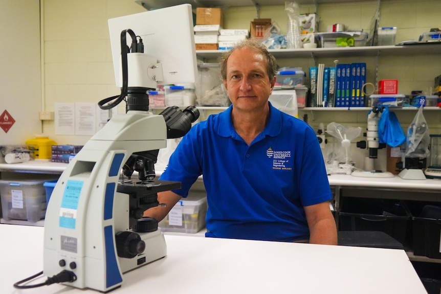 A man sitting at a microscope