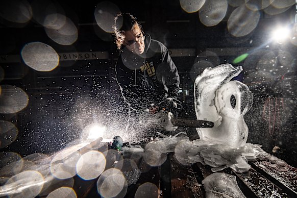 Chipping away: Kevin Kapusi Starow at work creating an ice sculpture swan.