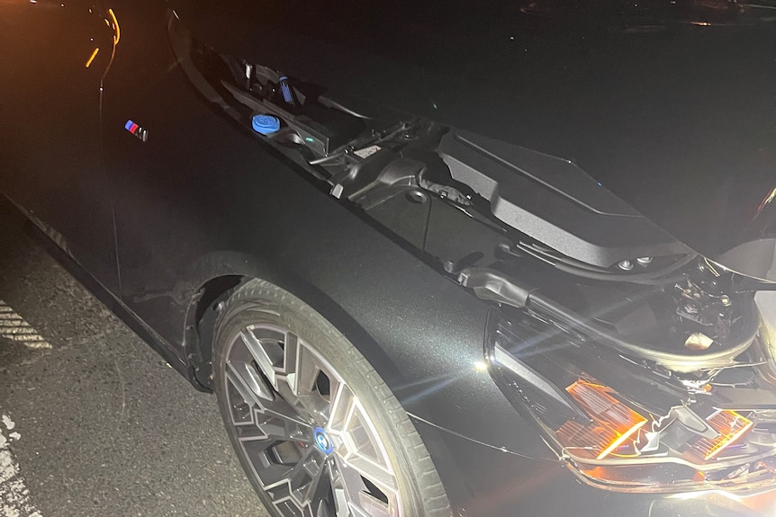 The damaged front of a black BMW.