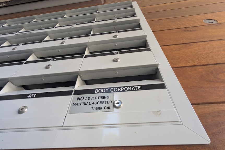 Letterboxes on a wall with "body corporate" on the first slot.
