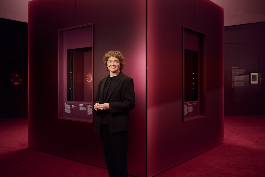 Dr Miranda Wallace pictured in a deep red coloured part of the Cartier exhibition