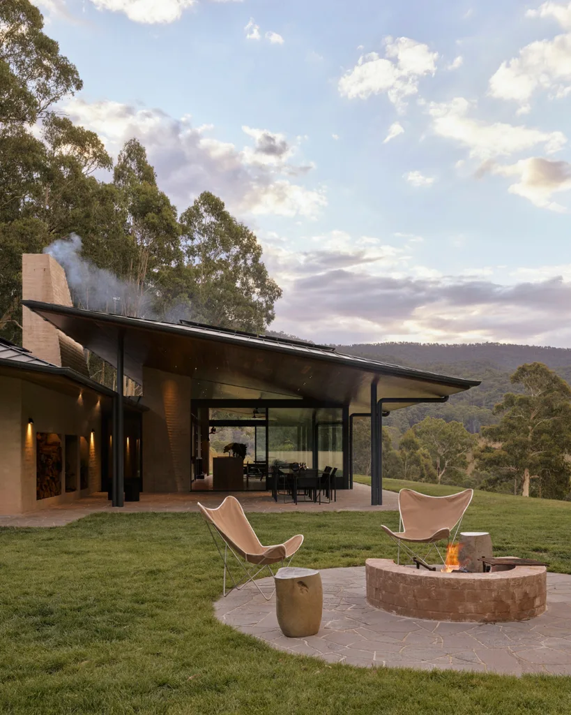 Wide eaves shield the home from the weather. ‘Butterfly’ chairs surround an outdoor fire pit.