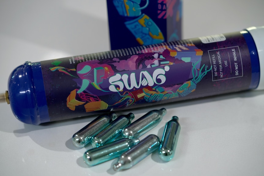 A large canister of nitrous oxide and small bulbs of nitrous oxide