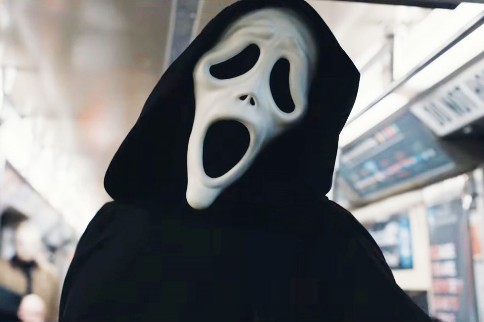 Person wearing a ghost face mask on a subway.