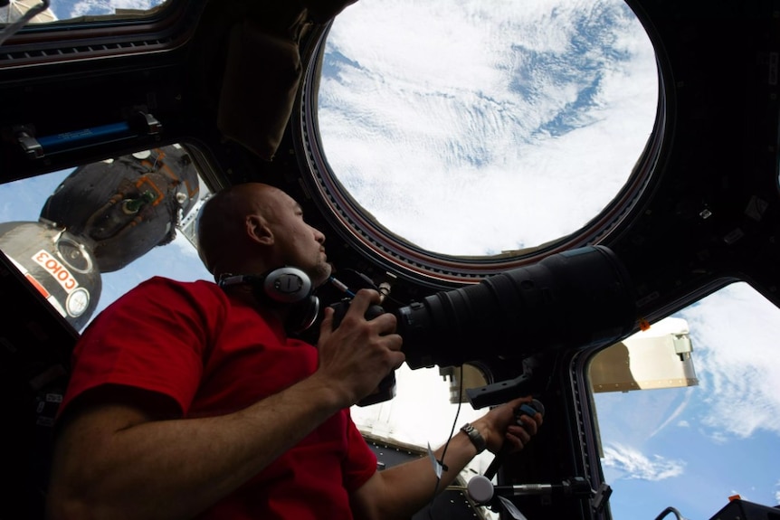 A man on the space station looking out the window.