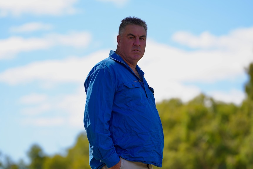 A white man in a blue shirt on a blue sky day
