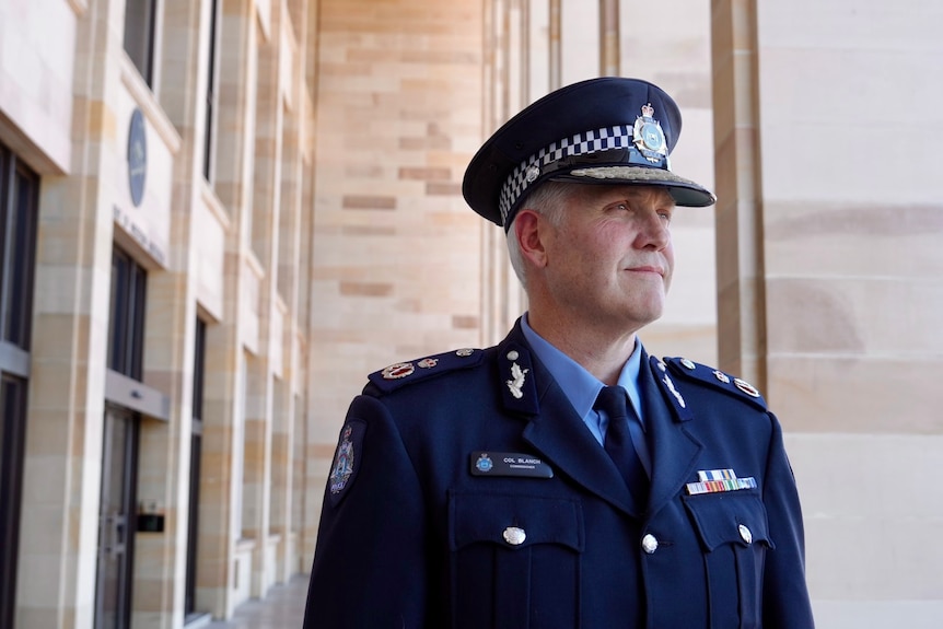 WA Police Commissioner Col Blanch standing outside Parliament House in Perth in front of TV microphones.