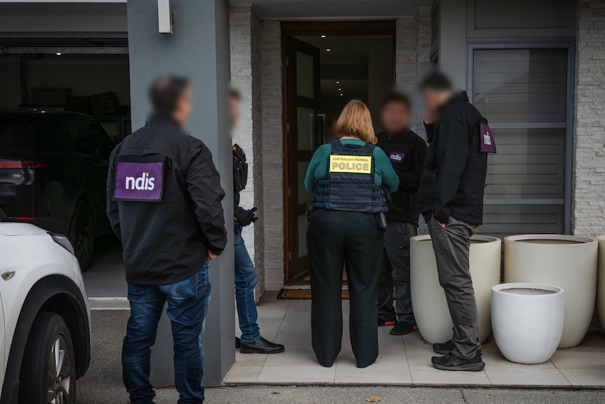 Police and people with NDIS on their uniform outside a house