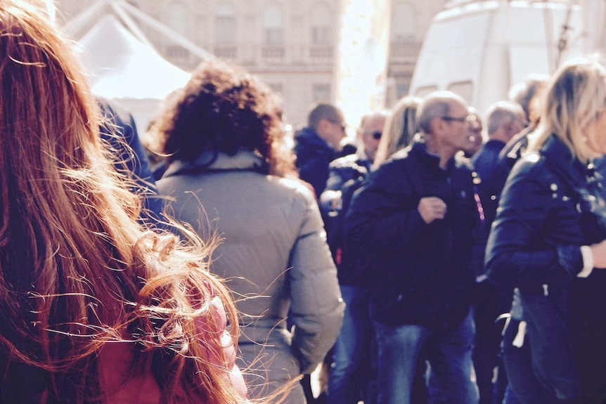 A crowd of people, all facing away from camera.